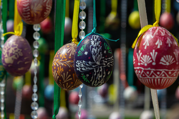 彩绘的彩蛋挂在复活节树的树枝上。重点是一个由孩子们手绘的黄色鸡蛋。图片下载