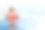 年轻女子放松在无边泳池与湖景。图片下载