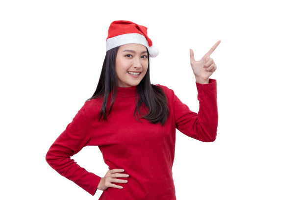 戴着圣诞帽的亚洲妇女指着空白的复制空间为圣诞销售内容图片下载