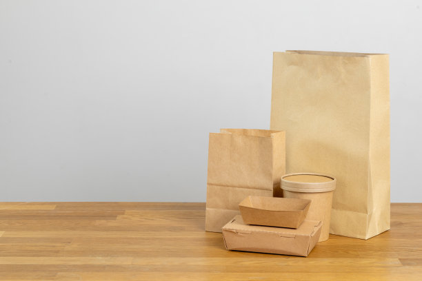 环保食品包装。纸张回收利用的天然产品为零废物。一盒用于食品一次性餐饮的纸，具有自然和可回收的概念。背景上无塑料设置。图片下载