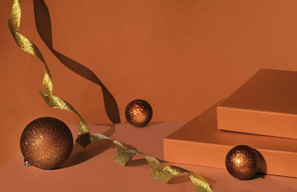 红色讲台上的礼品盒金色丝带。圣诞背景与平台的产品展示。红色的背景。图片下载