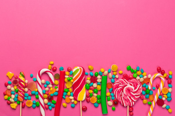 粉色背景上的彩色棒棒糖图片下载