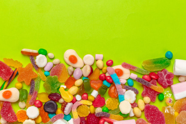 绿色背景上的彩色糖果图片下载