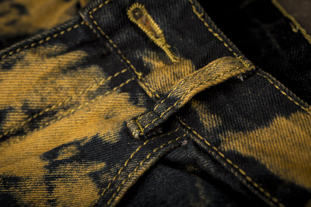 特写的深蓝色与棕色质感牛仔裤图片下载