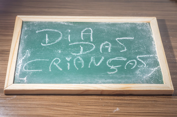 绿色的黑板，上面用白色的粉笔用葡萄牙语写着“儿童节”图片下载