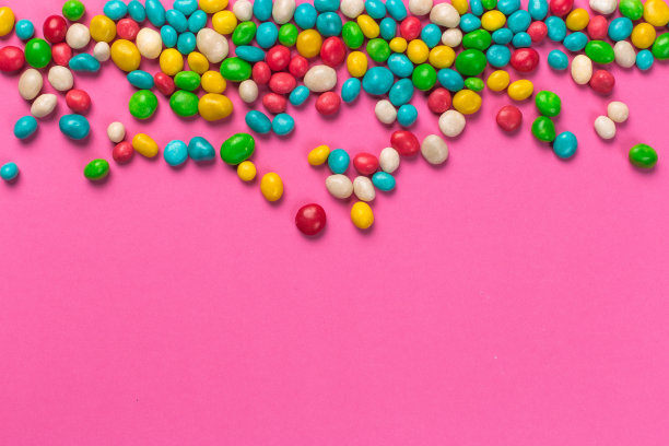 粉色背景上的彩色棒棒糖图片下载