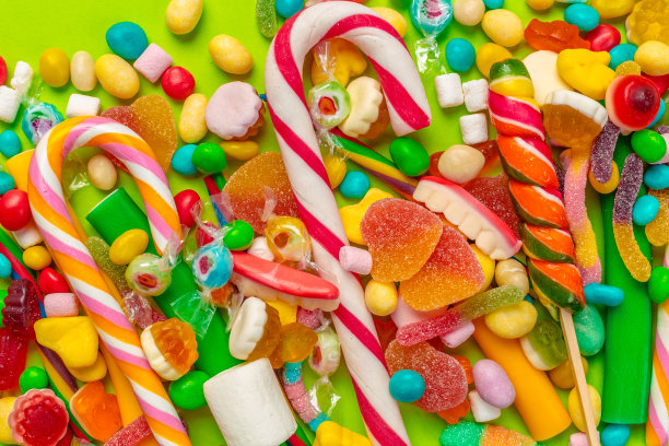 绿色背景上的彩色糖果图片下载