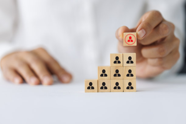 手拿着薄荷广场上方有人物图标的木块。建立强大的团队、人力资源理念和管理图片下载