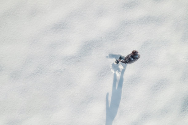 一个人在公园的雪地上打雪仗。冬天。无人机，顶部，鸟瞰图。图片下载