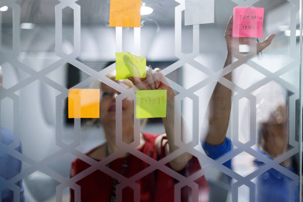 每个伟大的想法背后都有一个伟大的故事。同事们在头脑风暴会议上贴便利贴的照片。图片下载