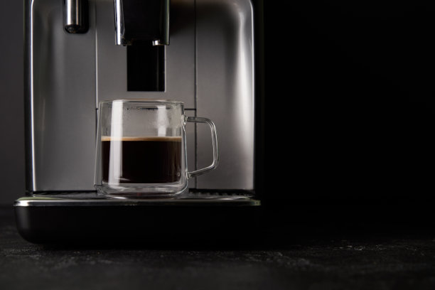 刚煮好的咖啡从咖啡机倒进玻璃杯里。图片下载