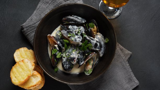 奶油白葡萄酒烩蓝贻贝，配蒜和香草。意大利或法国传统美食图片下载