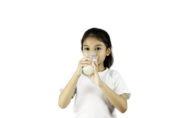 年轻的亚洲女孩在白色t恤喝牛奶从玻璃隔离在白色背景与修剪路径。图片下载