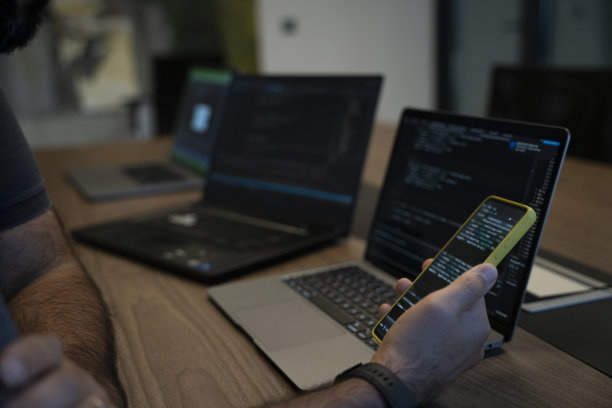 为移动设备开发软件的程序员检查他在手机上开发的软件。图片下载