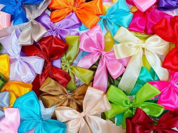 成堆的彩色手工丝带白色背景的礼物包装和头发装饰。图片下载