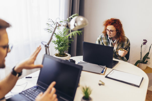 年轻的千禧一代夫妇在家工作。自由职业和远程工作的概念图片下载