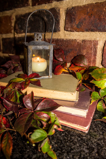 乡村静物的一堆旧书和灯笼形状的烛台图片下载