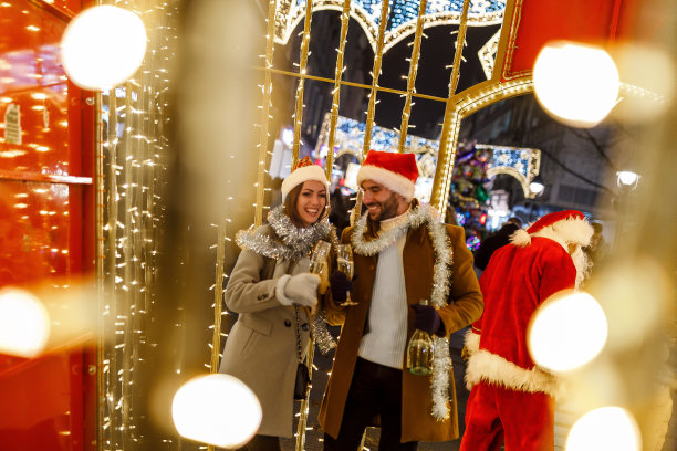 一对年轻夫妇走在街上喝着酒。图片下载