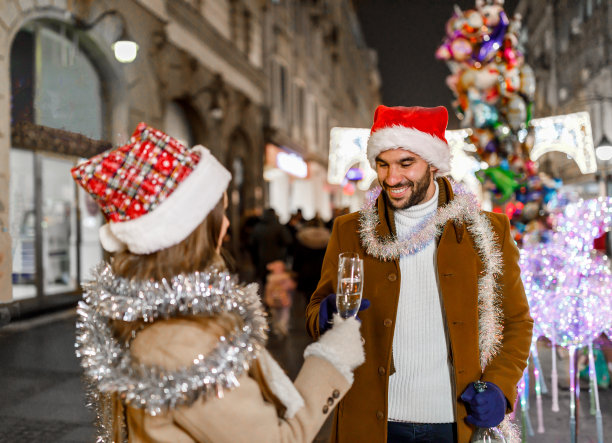 一对年轻夫妇走在街上喝着酒。图片下载