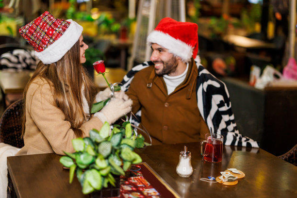 浪漫的年轻情侣在城市咖啡馆度过美好时光，享受圣诞之夜。图片下载