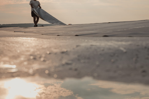 工人在屋顶小心地铺设PVC合成膜图片下载