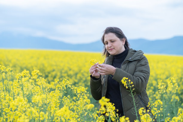 在油菜花田里的一位快乐的女农学家图片下载