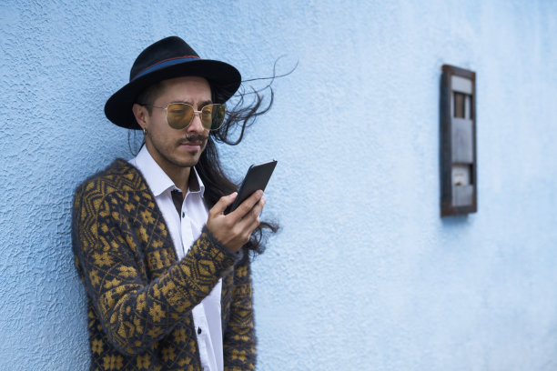 一个年轻人正在街上用手机和他的朋友聊天图片下载