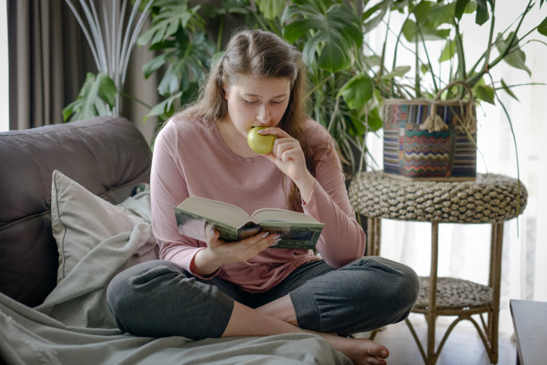 女人坐在沙发上看书图片下载