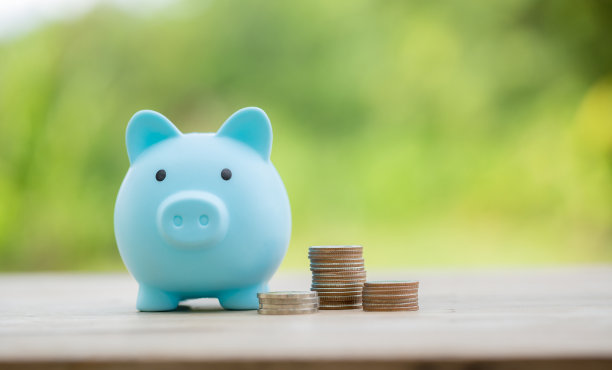 商业投资储蓄的概念。钱硬币堆叠在绿色背景的木质书桌上。管理现金，保险资产和财富，税务核算预算，增长贷款财务，经济。图片下载