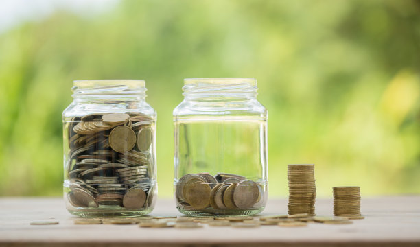 商业投资储蓄的概念。钱硬币堆叠在绿色背景的木质书桌上。管理现金，保险资产和财富，税务核算预算，增长贷款财务，经济。图片下载