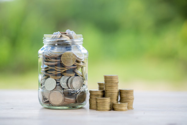 商业投资储蓄的概念。钱硬币堆叠在绿色背景的木质书桌上。管理现金，保险资产和财富，税务核算预算，增长贷款财务，经济。图片下载