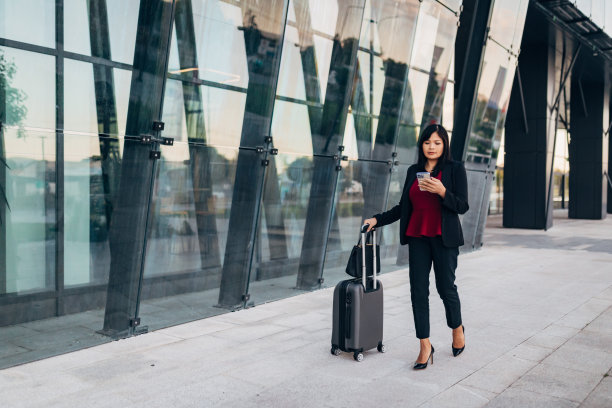 一个拖着个人行李的女企业家的全景图片下载