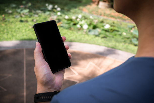 成年男子一边晨跑一边用手机看股市。过肩视图图片下载