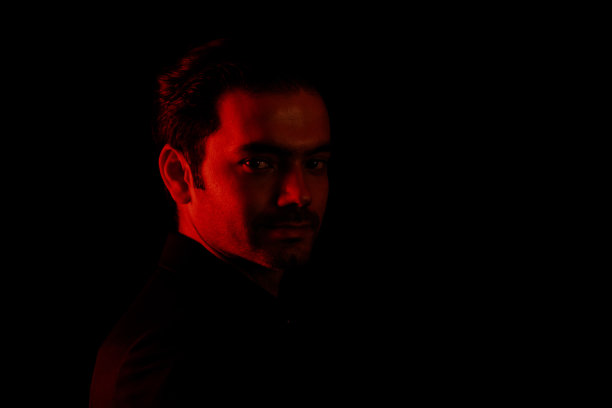 高对比度深色背景下的年轻男人肖像图片下载
