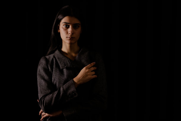 高对比度深色背景下的年轻女子肖像图片下载