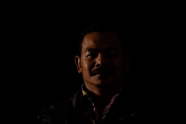 年轻人的肖像在高对比度的黑暗背景。图片下载