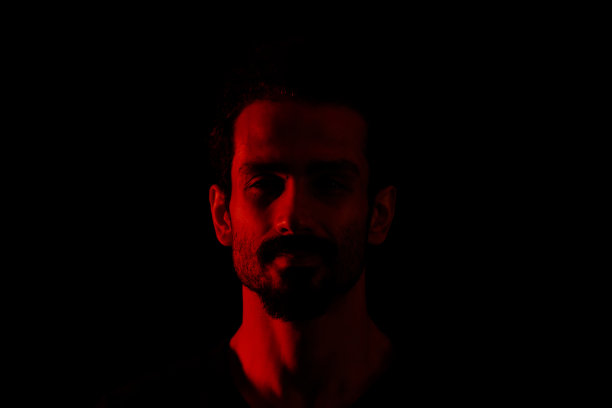 高对比度深色背景下的年轻男人肖像图片下载
