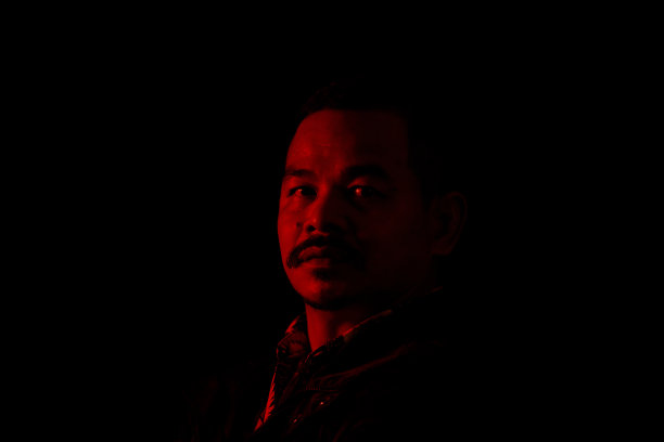年轻人的肖像在高对比度的黑暗背景。图片下载