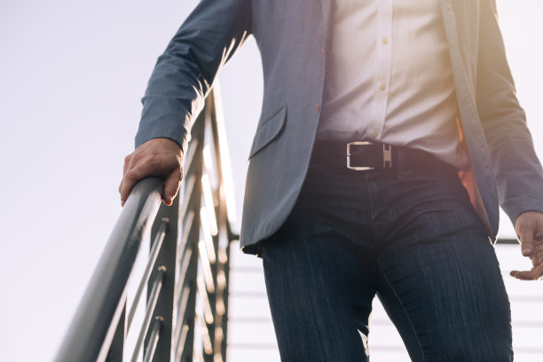 一个商人的背光中身的一部分和手臂抓住栏杆冲下来图片下载