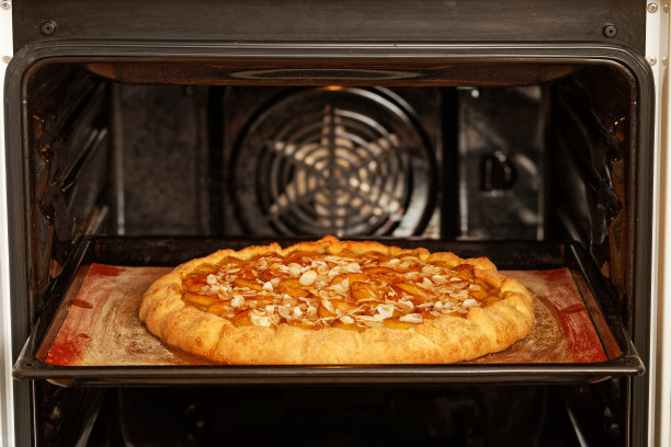 特写自制梅子派在家庭烤箱烘焙。浅的焦点。图片下载