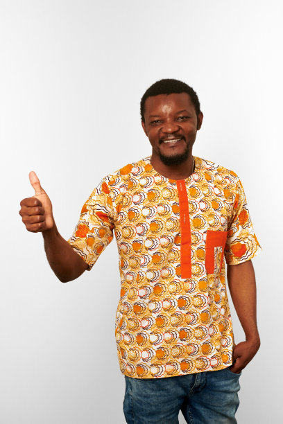 微笑的黑人，拇指向上的手势，非洲明亮的衣服孤立在白色的背景图片下载