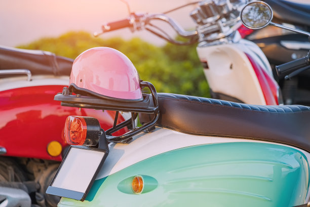 女性粉红色可爱的头盔和老式摩托车在城市停车场图片下载