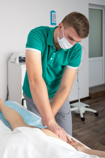 按摩师按摩女腿上的肌肉。图片下载