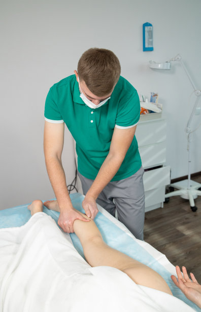 按摩师按摩女腿上的肌肉。图片下载