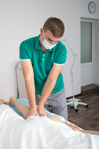 按摩师按摩女腿上的肌肉。图片下载