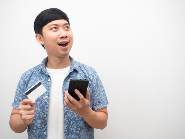 男子拿着信用卡和智能手机看着拷贝空间感到惊讶图片下载