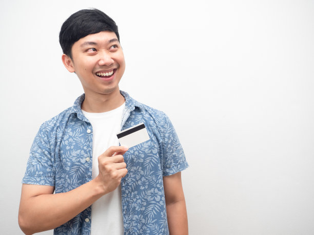 蓝衬衫男子拿着信用卡，看着复印空间图片下载