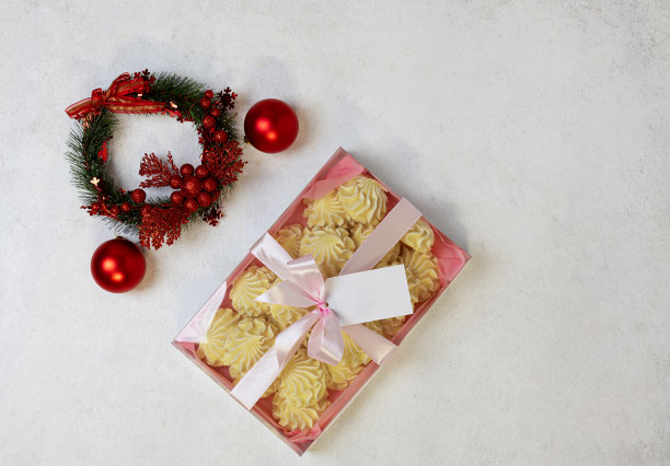 红色的圣诞球，在明亮的背景上有蜡烛。有选择性的重点。复制的空间。从以上观点。图片下载