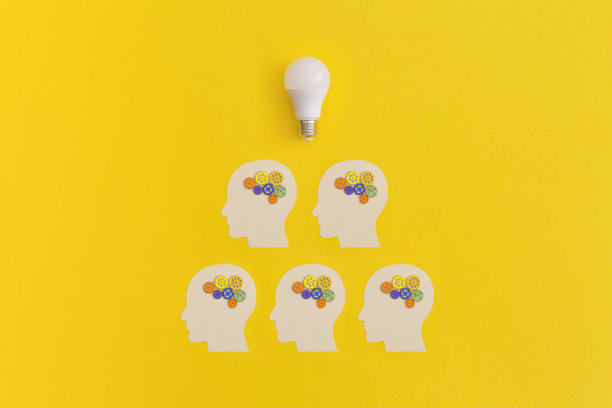 黄色背景上有齿轮的人头。灵感和创意观念。图片下载