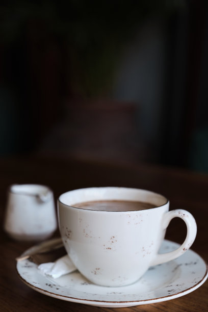 桌上的一杯咖啡，老式的彩色照片，照片中的胶片噪音和纹理。垂直框架，选择性对焦，模糊背景。关于屏幕保护程序或菜单的想法，关于咖啡的文章图片下载